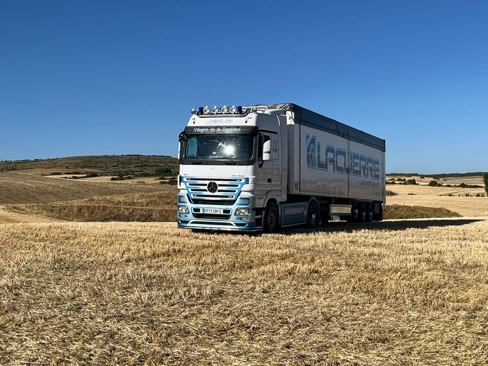 Mercedes-Benz Actros truck de Lacuerre Landwirtschaft en campo agrícola con paisaje de Cantabria al fondo